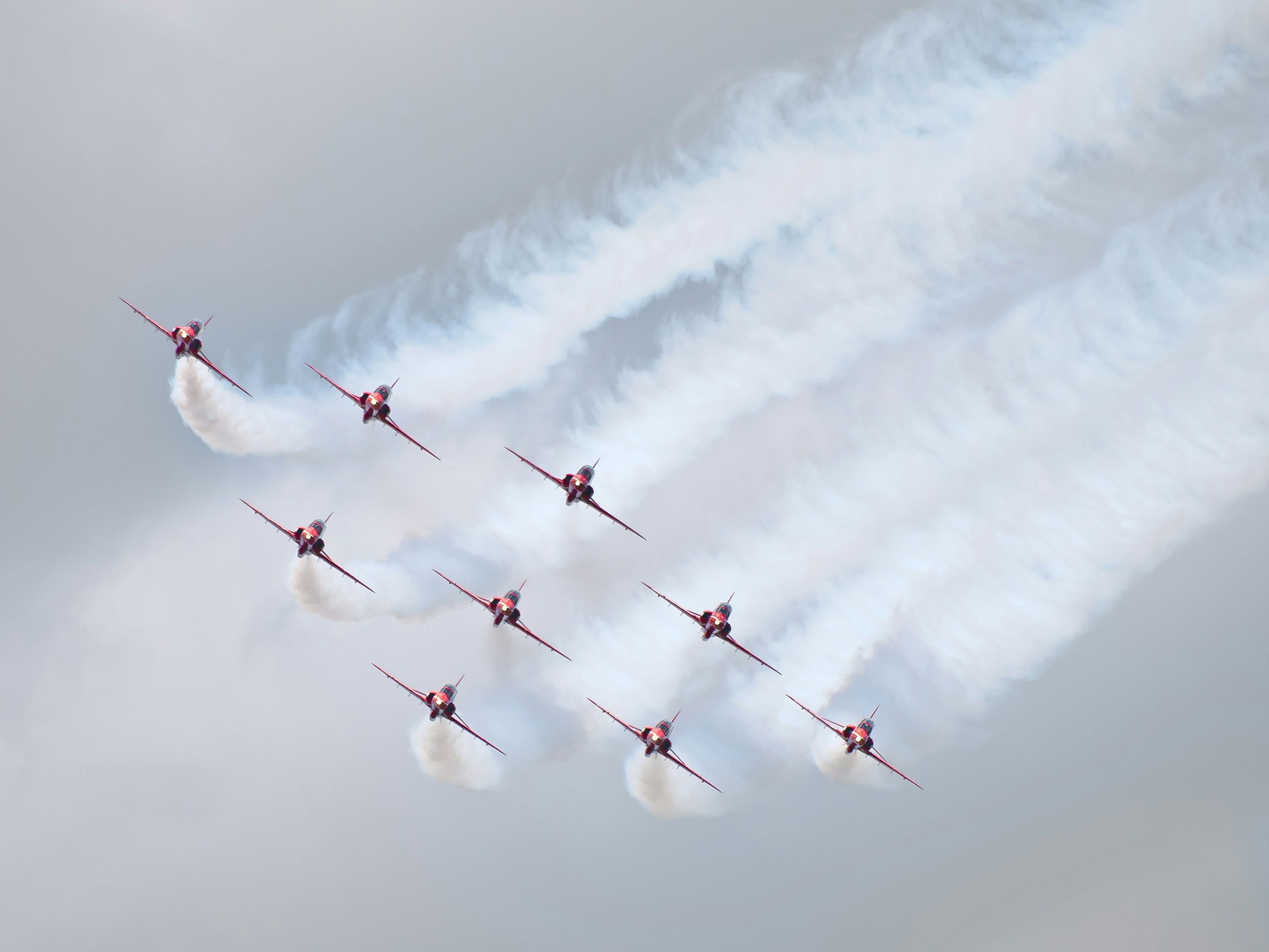 Red Arrows flying in formation with white smoke